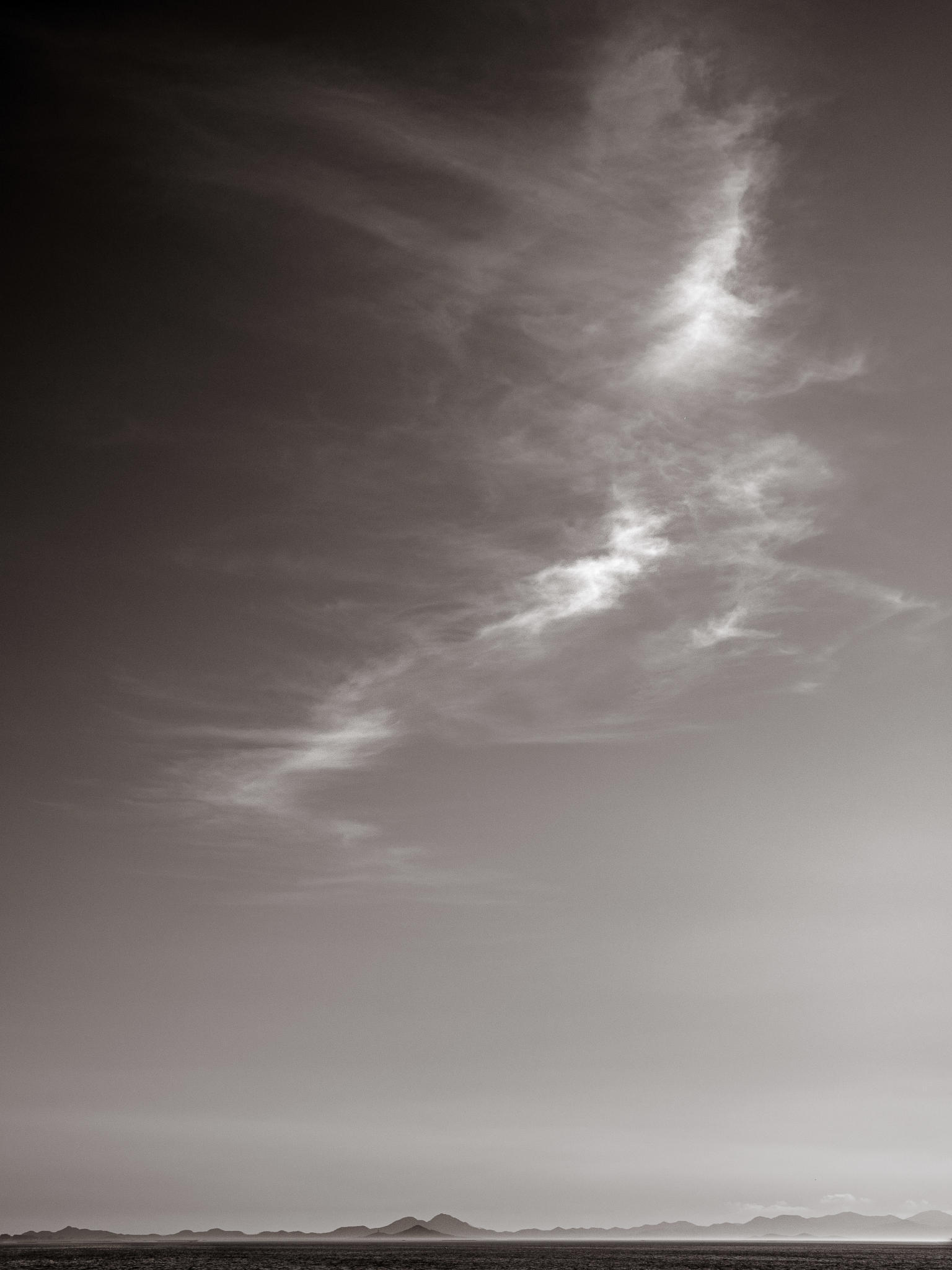 Dark Days Photography Landscape ‘Unicorn’ by Harri Jahkola, Mar Menor, Spain, with cloud patterns, showcasing 25+ years of travel and landscape photography expertise.